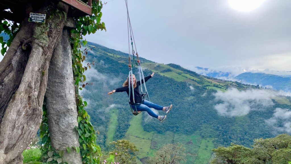 woman swinging over mountain in Banos, Ecuador