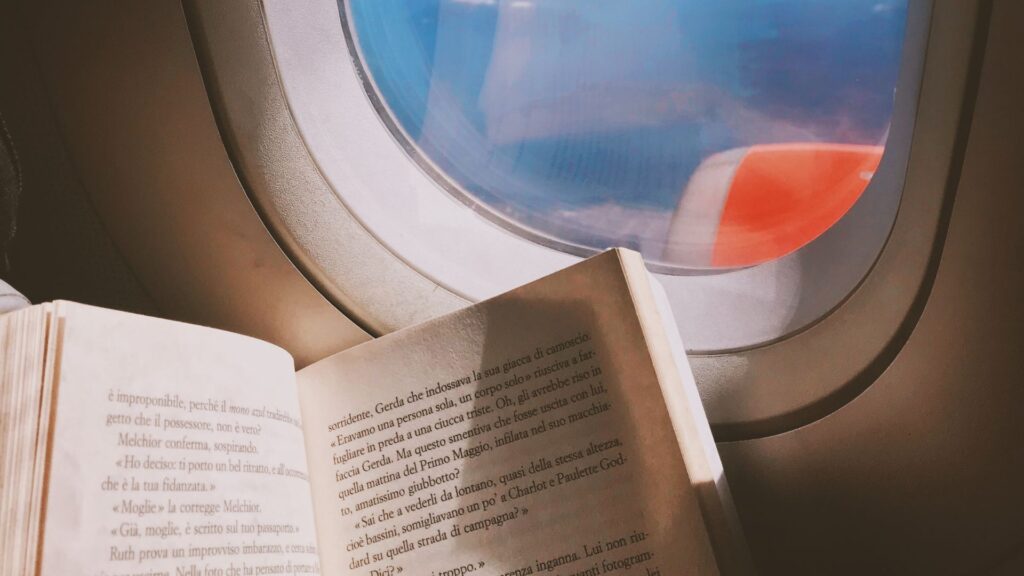 Best Books to Read on a Plane - Book and Plane Window