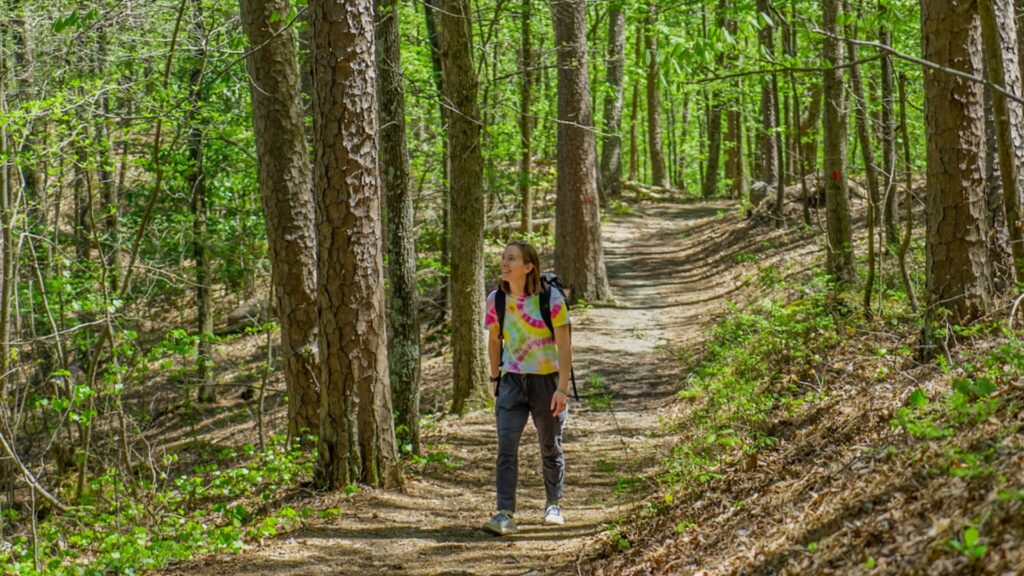 Woman hiking in forest - best Hot Springs National Park Trails