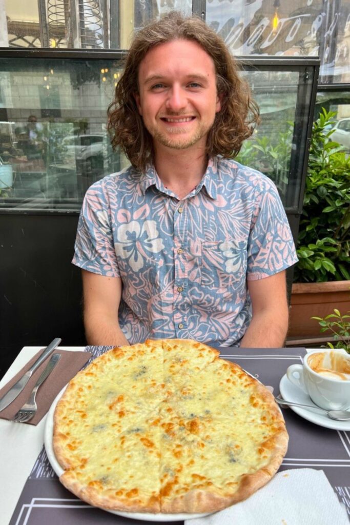 Man eating Quattro Formaggi Pizza - Must Try Foods in Italy