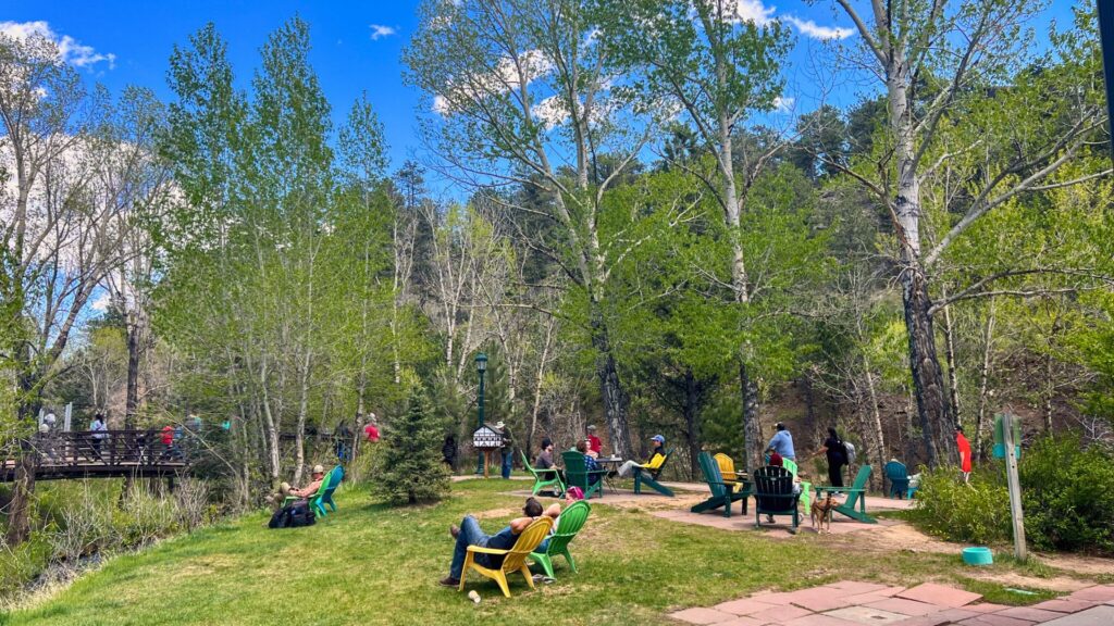 Outdoor seating by the river at Kind Coffee in Estes Park