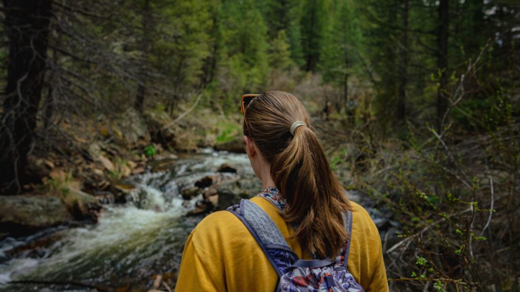 Woman hiking near river in Estes Park, Colorado