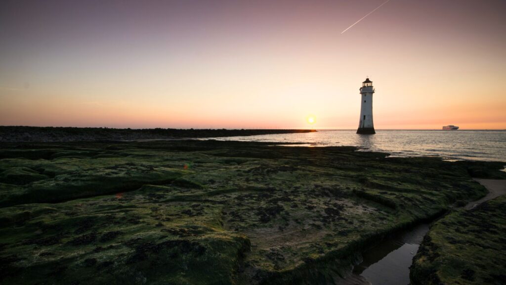 Lighthouse off the Seashore at Sunrise