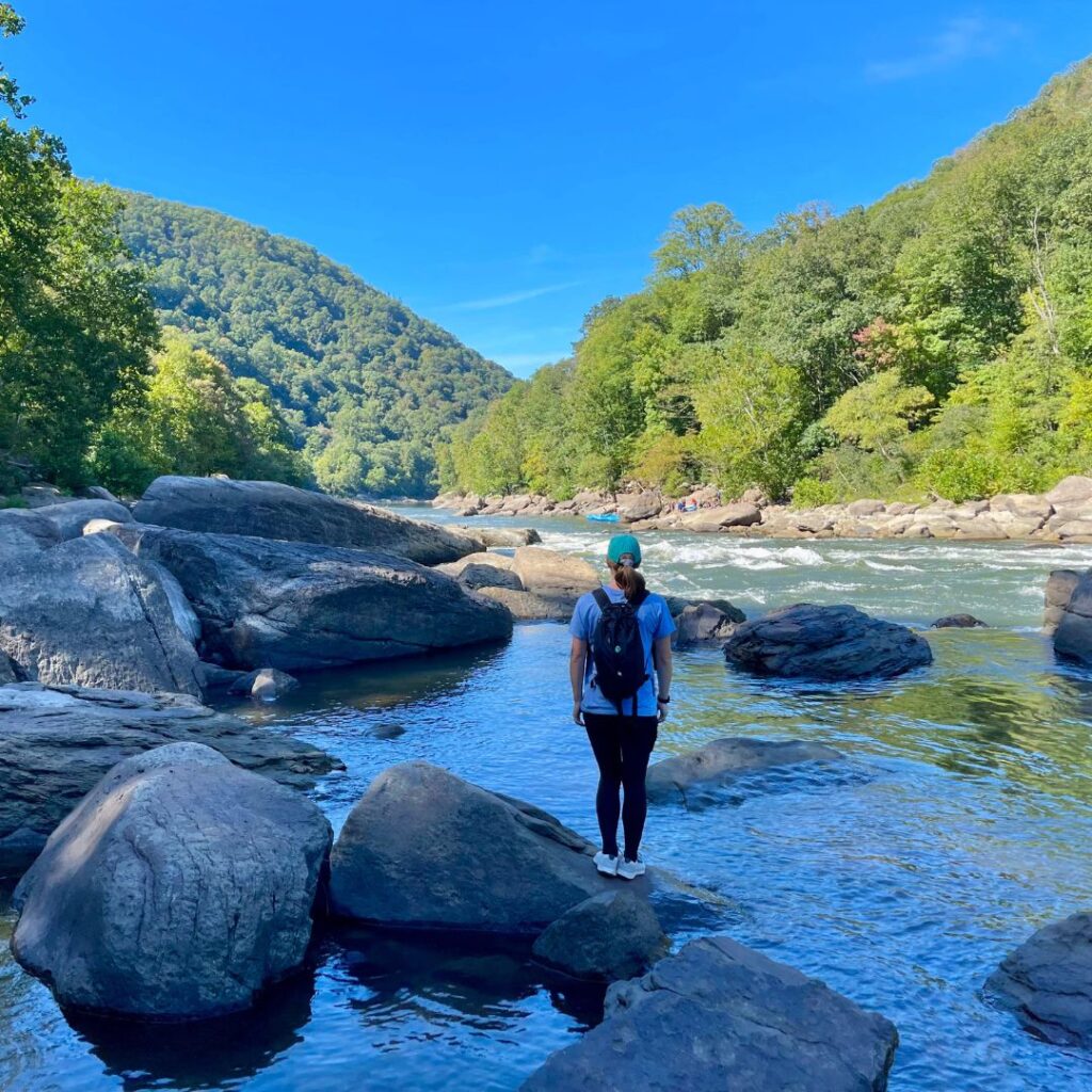 Woman by the river in New River Gorge National Park