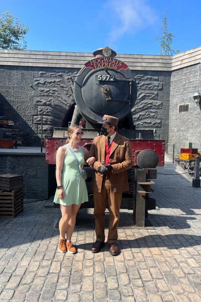 Woman with train conductor in Hogsmeade Universal Studios (me)