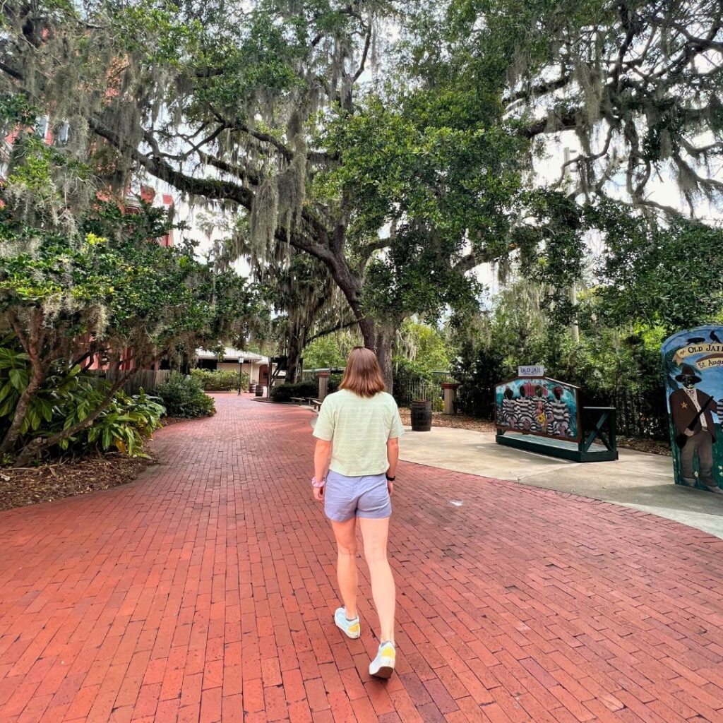 Woman walking through mossy trees in St Augustine