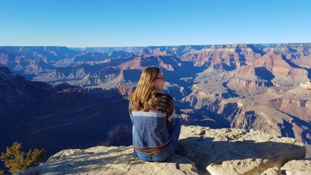 Woman sitting on rim of Grand Canyon