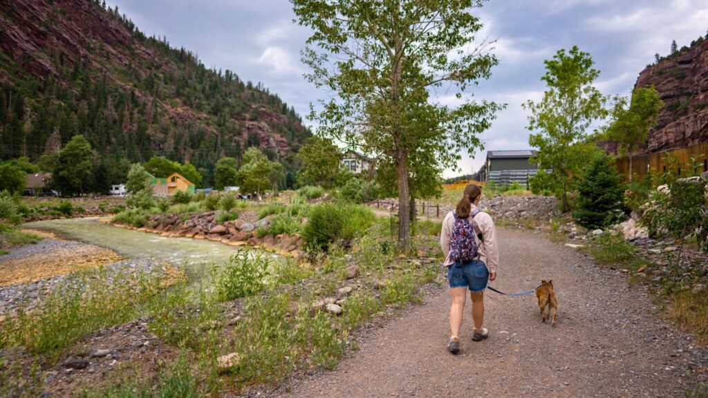 Woman and Dog hiking by river in Ouray Colorado