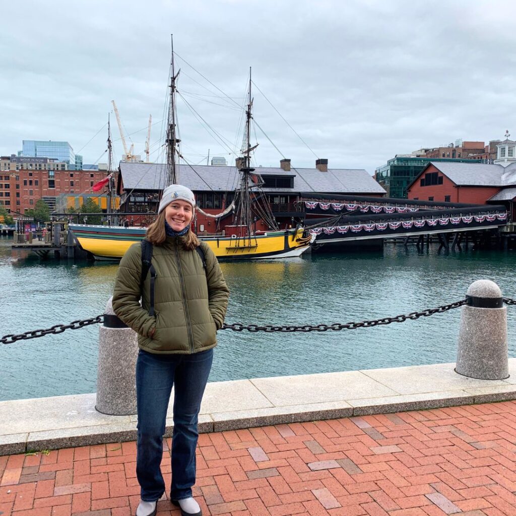 woman standing by Boston Harbor in fall