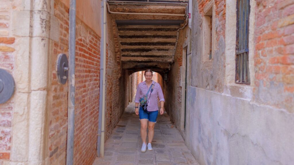 Woman walking down alley in Venice Italy